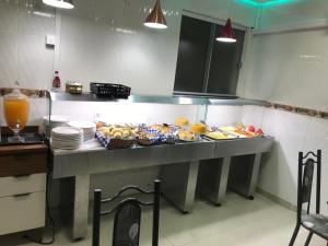 a kitchen counter with a bunch of food on it at Hotel Monte Belo Palace in Aparecida +26 photos