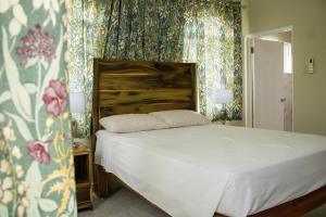 a bedroom with a bed with floral wallpaper at DEMAROYS in Treasure Beach