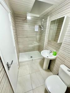 a bathroom with a shower and a toilet and a sink at Cosy 3 Bed Apartment,Free Parking in Birmingham in Birmingham