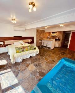 Peatonal Suites Paraná في بارانا: غرفة نوم بسرير كبير ومسبح