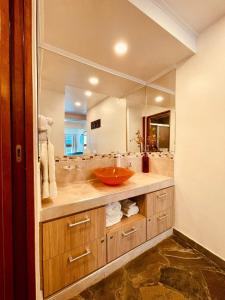 La salle de bains est pourvue d'un lavabo et d'un grand miroir. dans l'établissement Peatonal Suites Paraná, à Paraná