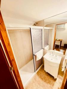 a small bathroom with a shower and a sink at Peatonal Suites Paraná in Paraná