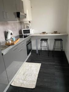 a kitchen with a counter and two stools in it at Sweet Home 10min from DisneyLand Paris and 25min from Paris in Bussy-Saint-Georges