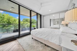 a bedroom with a large bed and a large window at Impeccably Chic 3-Bed Apartment Just Outside CBD in Campbell