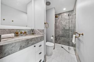 a bathroom with a sink and a shower at Impeccably Chic 3-Bed Apartment Just Outside CBD in Campbell