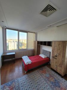 a bedroom with a red bed and a large window at Journey's Ease in Istanbul