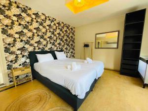 1 dormitorio con 1 cama grande con sábanas blancas en House Xxl Free Parking 3 Bedrooms, en Tilburg
