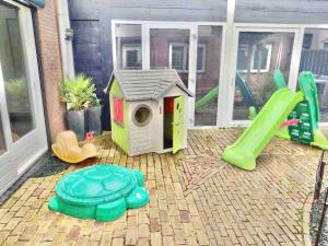 un parque infantil con una casa para perros y un tobogán en House Xxl Free Parking 3 Bedrooms, en Tilburg