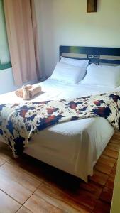 a large bed with a blanket on top of it at Pousada Pouso das Águias in Nova Veneza