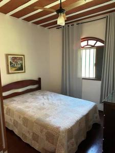 een slaapkamer met een bed, een raam en een plafond bij Casa no campo in Bom Jardim
