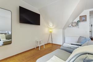 ein Wohnzimmer mit einem Sofa und einem TV an der Wand in der Unterkunft Luxus Apartment Lüdinghausen in Lüdinghausen