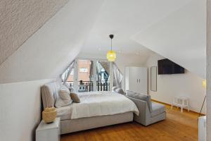 ein weißes Schlafzimmer mit einem Bett und einem Stuhl in der Unterkunft Luxus Apartment Lüdinghausen in Lüdinghausen