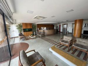 a large living room with chairs and a table at Flats beira mar - praia da costa in Vila Velha