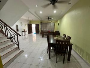 a dining room and living room with a table and chairs at Casa Lily Residence IM8 in Kuantan