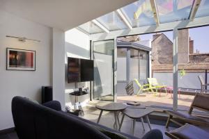 a living room with a view of a patio at La Terrasse des Climats in Beaune