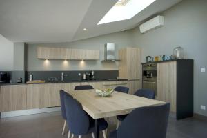 a kitchen with a wooden table and blue chairs at La Terrasse des Climats in Beaune
