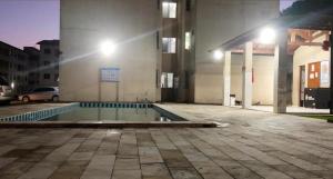 une piscine vide devant un bâtiment la nuit dans l'établissement Apartamento Home Practice Flat, à São Luís