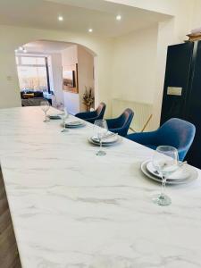 a long table with plates and wine glasses on it at *Newcastle City* Modern 2 Bedroom House in Newcastle upon Tyne