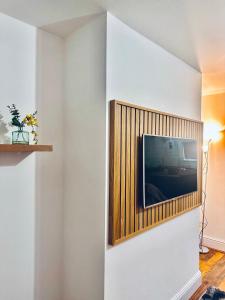 uma sala de estar com televisão na parede em *Newcastle City* Modern 2 Bedroom House em Newcastle upon Tyne