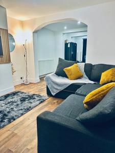 uma sala de estar com um sofá azul e almofadas amarelas em *Newcastle City* Modern 2 Bedroom House em Newcastle upon Tyne