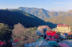 a group of buildings with mountains in the background at The Regency by Boho Stays in Shimla