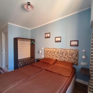 um quarto com uma cama e uma cabeceira em madeira em 9 Doors em Tbilisi