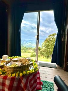 a table with a basket of food in front of a window at Refugio Aventura, romántico glamping montañero in Tabio