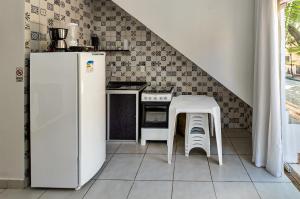 uma cozinha com um frigorífico branco e uma mesa em Flats Ledy em Cairu