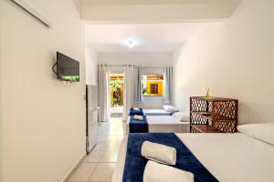 ein Hotelzimmer mit 2 Betten und einem TV in der Unterkunft Flats Ledy in Cayru