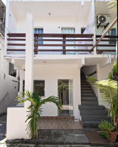 una casa blanca con escaleras y plantas en Flats Ledy en Cairu