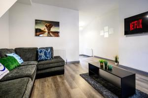 a living room with a couch and a table at Manchester Serviced Accommodation NorthernNightzzz - The Park in Manchester