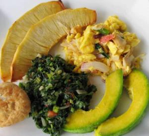 a plate of food with eggs and vegetables and a pickle at The Resort at West End in Negril