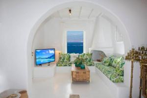 a living room with a couch and a tv at Azure Horizon Suites & Villas - Mykonos in Agios Ioannis Mykonos