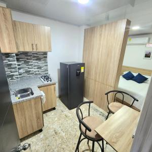cocina con nevera, mesa y sillas en Apartamentos todos con aire acondicionado, en Ibagué