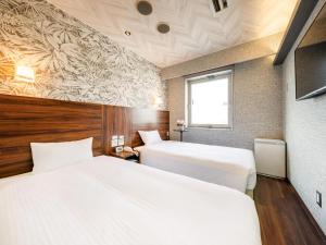 En eller flere senge i et værelse på Tokai City Hotel