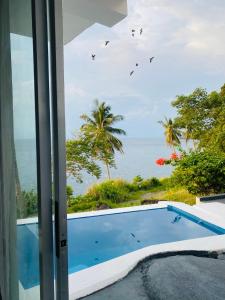 a view of the ocean from a house with a swimming pool at Bintana Sa Paraiso in Mambajao