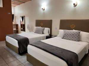 Jalostotitlán的住宿－Hotel & Eventos Xalos，一间酒店客房,房间内设有两张床