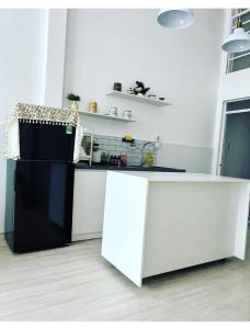 a kitchen with white counters and a black refrigerator at December HomeStay Studio in Ho Chi Minh City