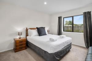 a bedroom with a bed and a window at The Tin Hut - Kinloch in Kinloch