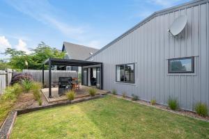 a backyard with a grill and a house at The Tin Hut - Kinloch in Kinloch