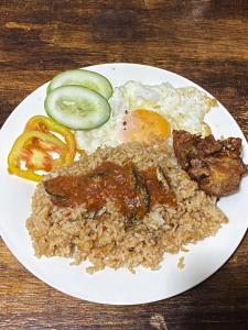 un plato de comida con arroz y carne y hortalizas en Alegreya Homestay + Cafe, en General Luna