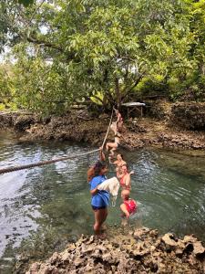 a group of people in the water in a river at Alegreya Homestay + Cafe in General Luna
