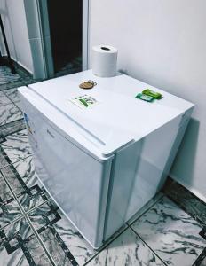 a white refrigerator with a roll of toilet paper on top at Lemon Suítes e Pousada - Indaiá Riviera in Bertioga