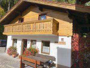 a building with a balcony on top of it with a bench at Haus Mayerbüchler - Chiemgau Karte in Inzell