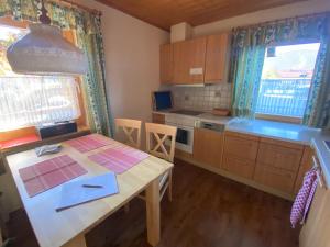 a kitchen with a wooden table and a table and some windows at Haus Mayerbüchler - Chiemgau Karte in Inzell