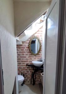 a bathroom with a white sink and a brick wall at 9 Doors in Tbilisi City +50 photos
