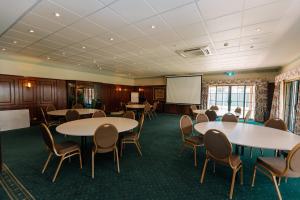 uma sala de conferências com mesas e cadeiras e um quadro branco em The Lawson Riverside Suites em Wagga Wagga
