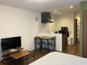 een kamer met een keuken en een kleine tafel met stoelen bij GEビルAFUSO in Atsutabaru