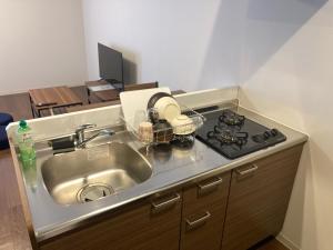 een keuken met een spoelbak en een fornuis bij GEビルAFUSO in Atsutabaru