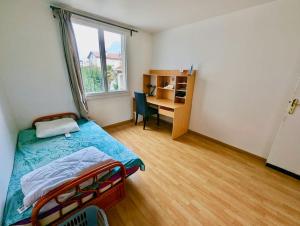 a bedroom with a bed and a desk with a window at Superbe Chambre - Calme & Propre in Grenoble